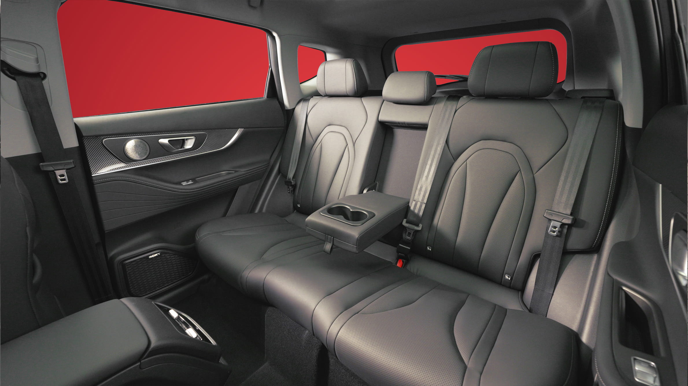 Rear seat view of a car interior with leather upholstery and seatbelts.