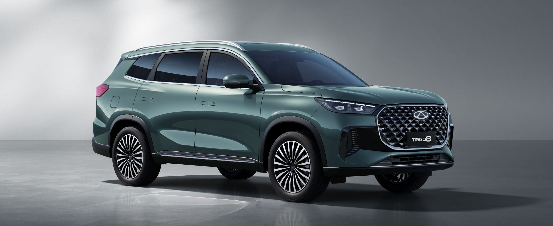 Green SUV with geometric grille and modern design, shown in profile view.