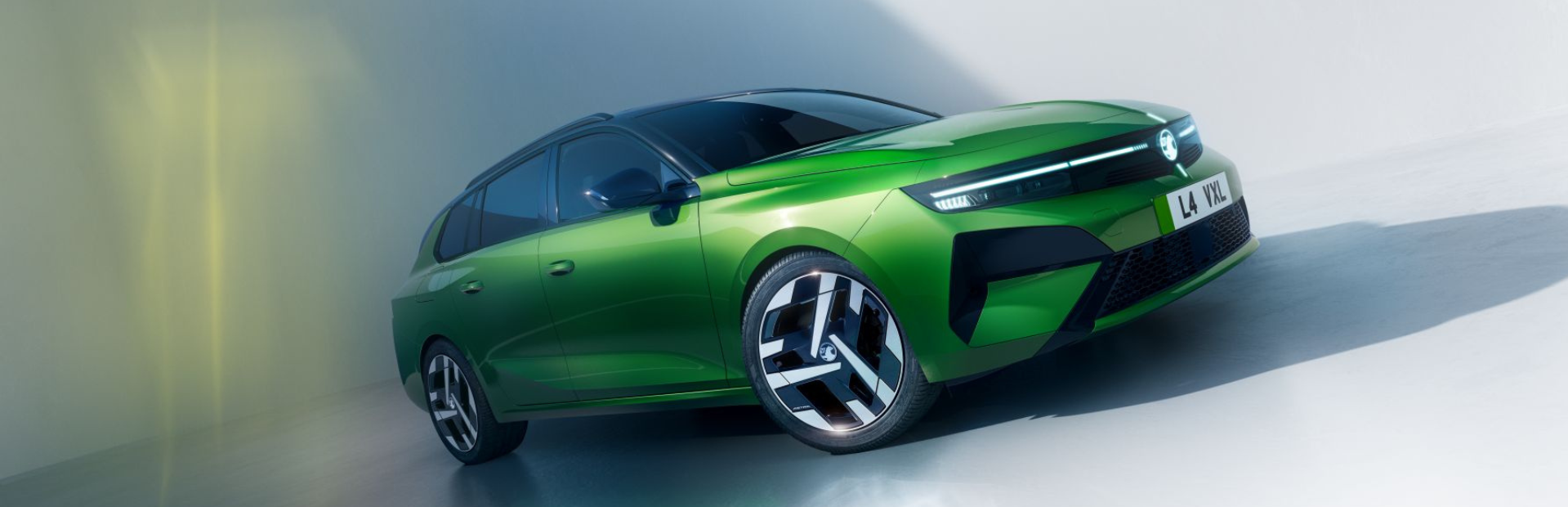Green car with a futuristic design and distinctive headlights.